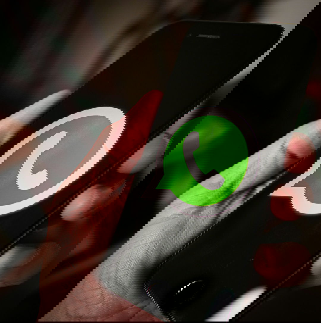 a-person-holding-a-cell-phone-with-a-whatsapp-on-it.jpg a person holding a cell phone with a whatsapp on it